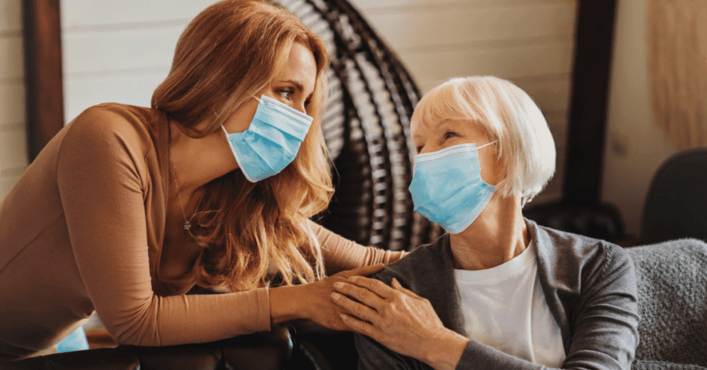 Two masked women talking